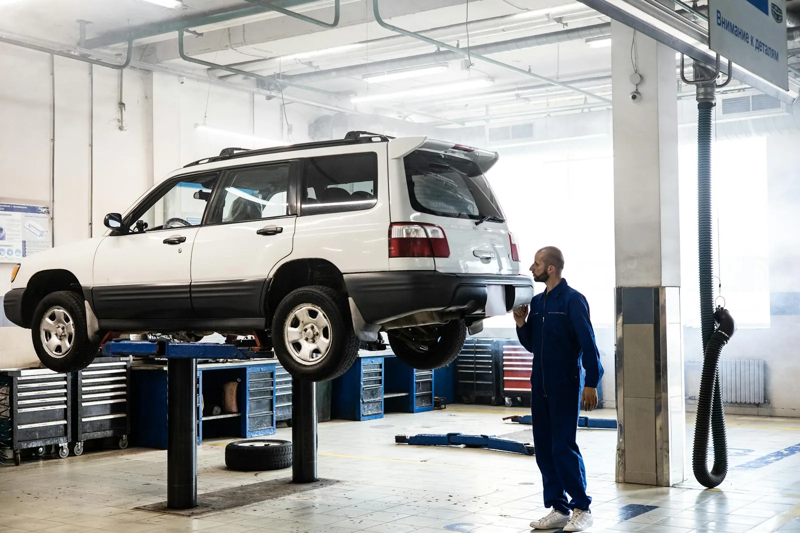 Mekaanikko tarkastaa autoa katsastuksen hylkäyksen ja korjaustarpeen vuoksi